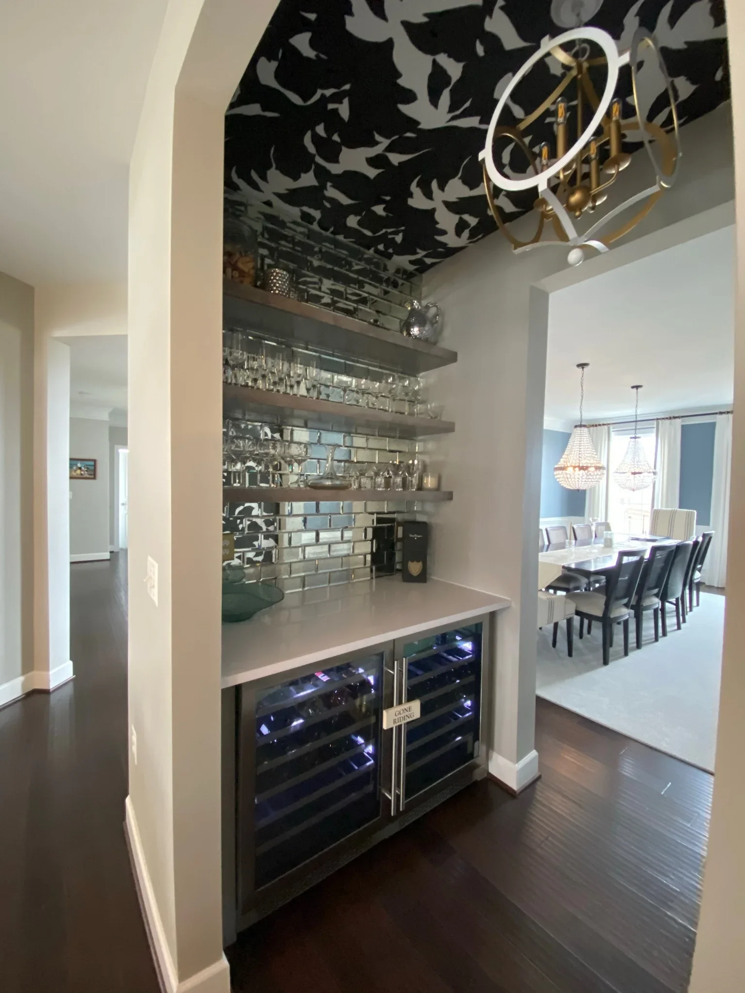 Wet bar with subway tile backsplash, floating shelves, dual wine coolers, and quartz countertop