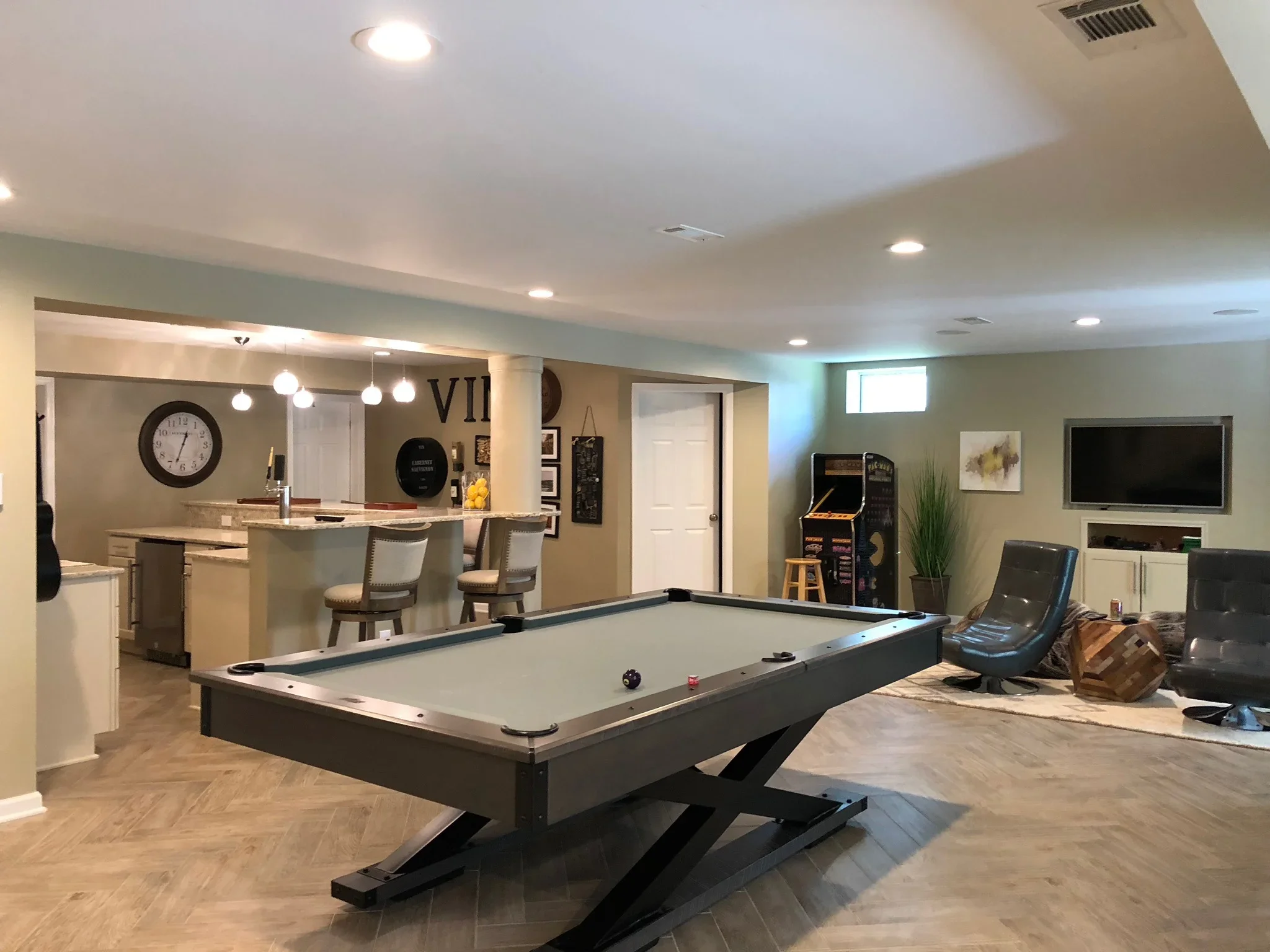 Basement recreation room with wet bar, pool table, recessed lighting, and vinyl plank flooring