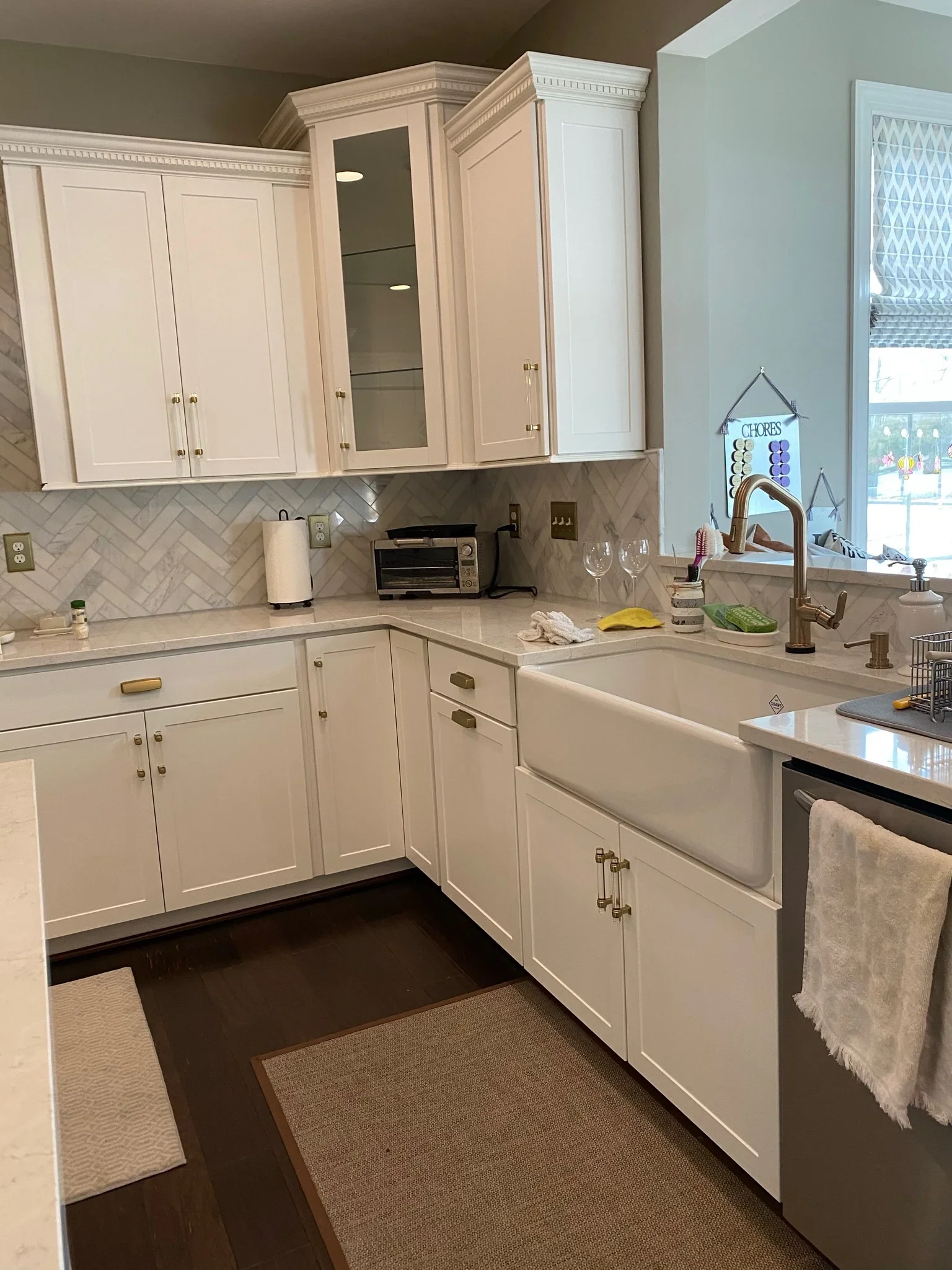 White shaker cabinets, quartz counters, herringbone tile backsplash, farmhouse sink