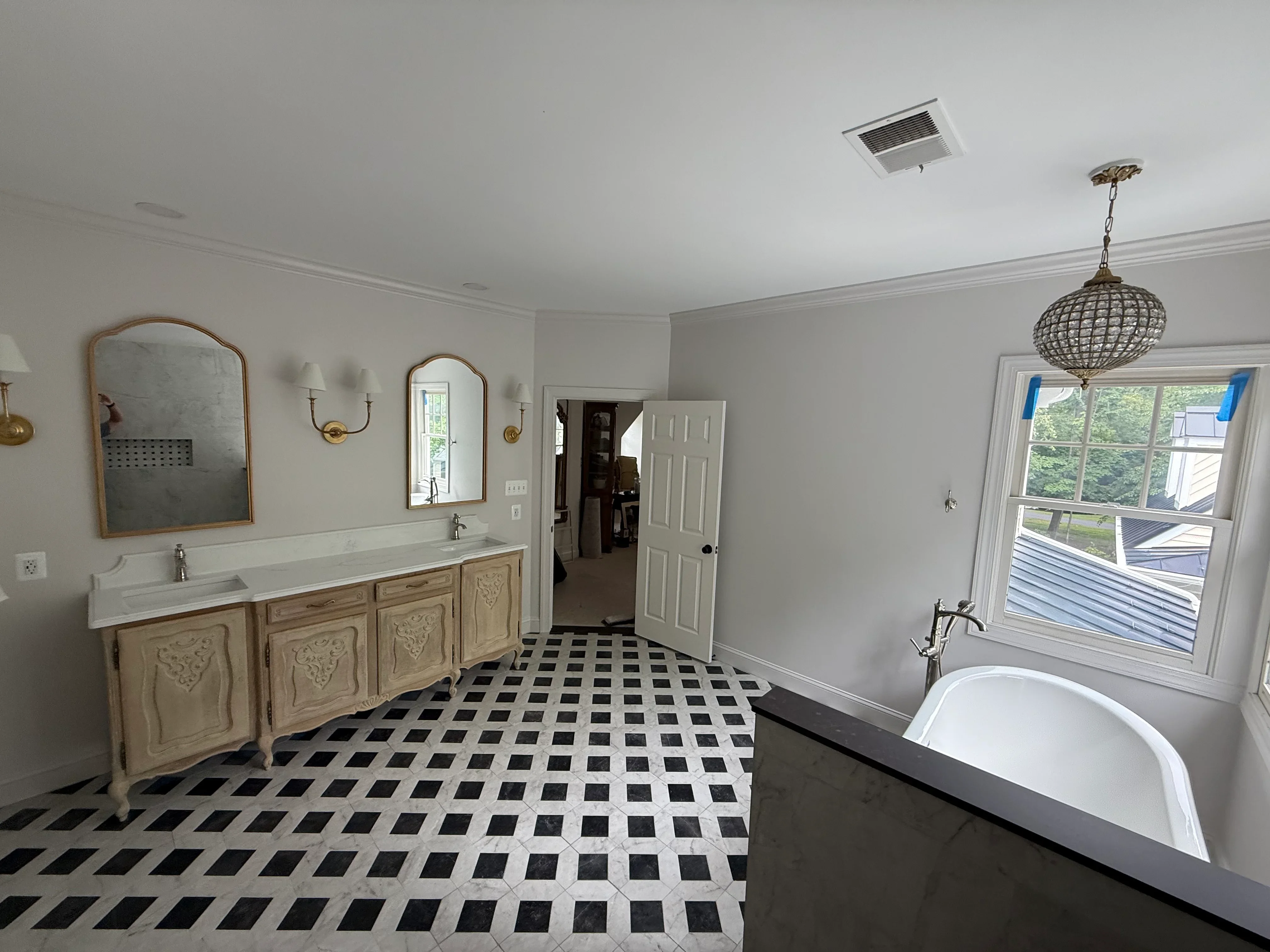 Master bathroom with dual vanity, diamond tile floor, freestanding tub, and brass fixtures